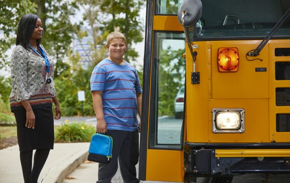 Adolescent Male Getting on School Bus
