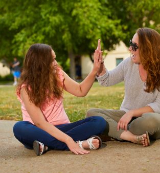 Women and female adolescent high fiving