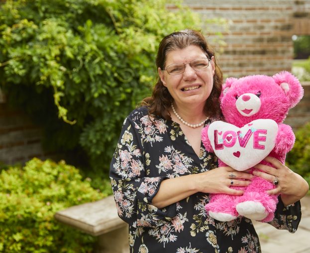 Damar client holding pink teddy bear