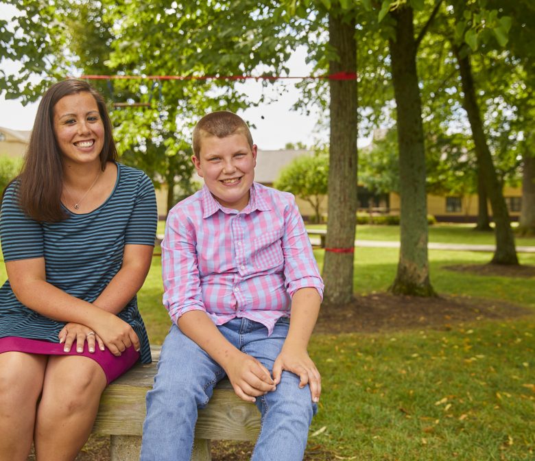 Female staff member and adolescent male client smiling