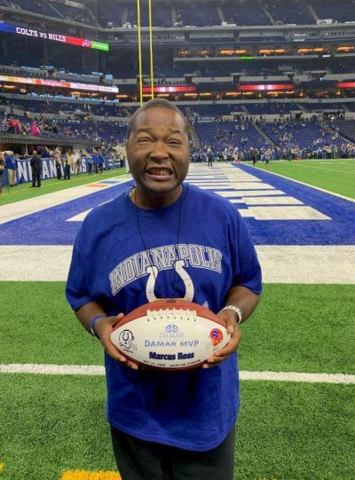 Marcus holding football at Colts game