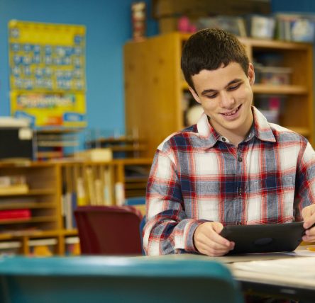 Adolescent Male Using Tablet at School