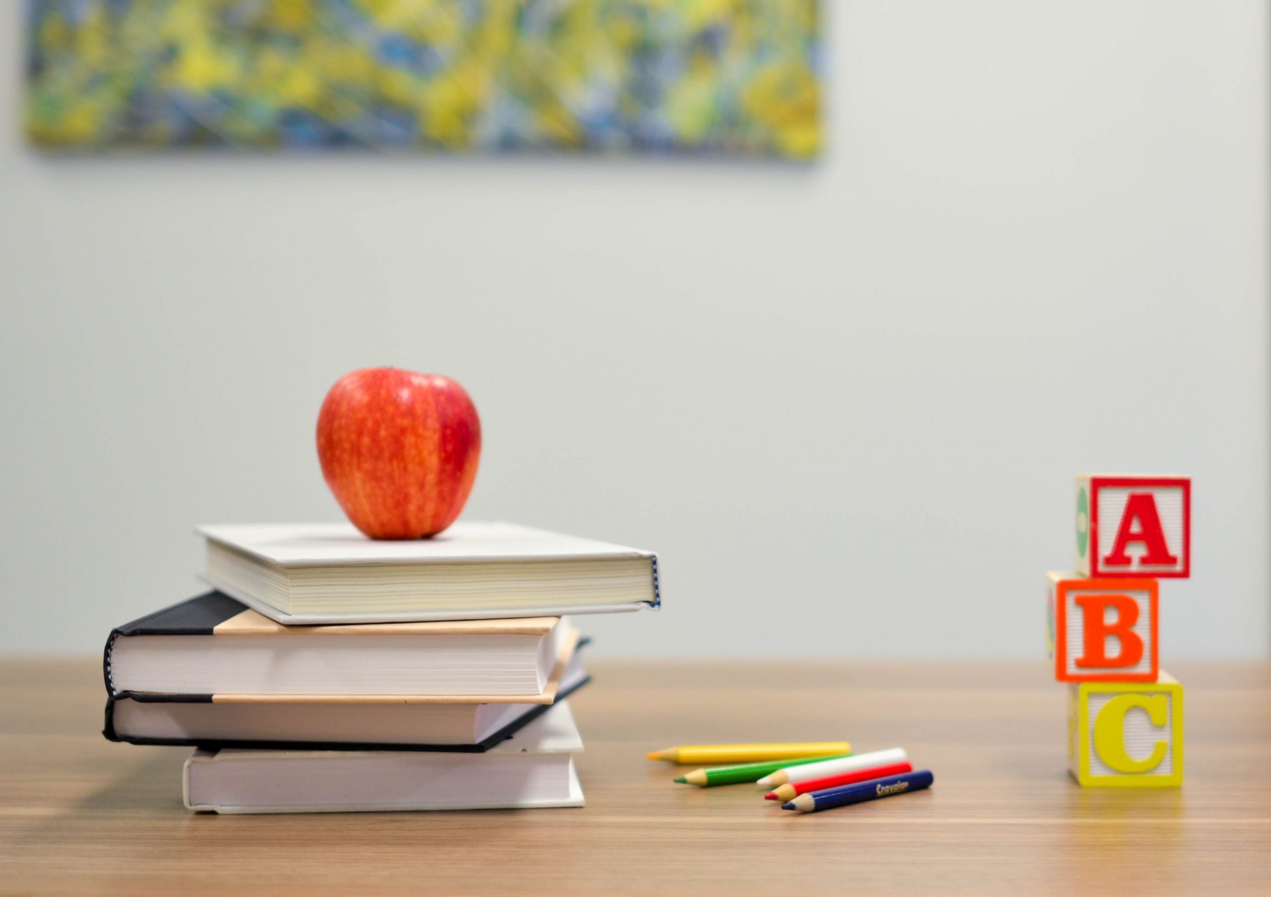 teacher's desk with apple, books, and blocks