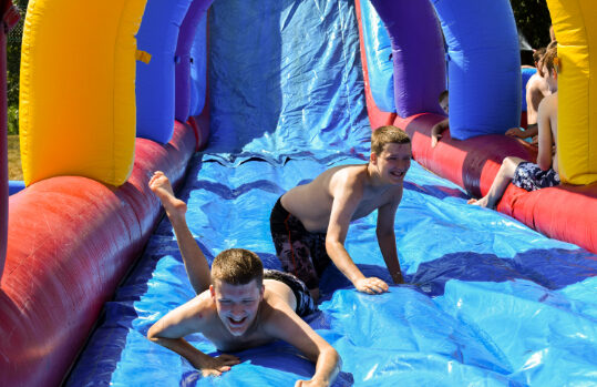 Damar clients sliding down inflatable slide