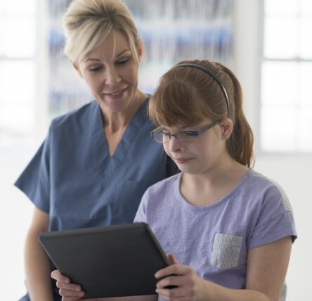 Female staff with adolescent female client on tablet