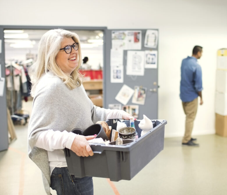 Smiling volunteer carrying crate