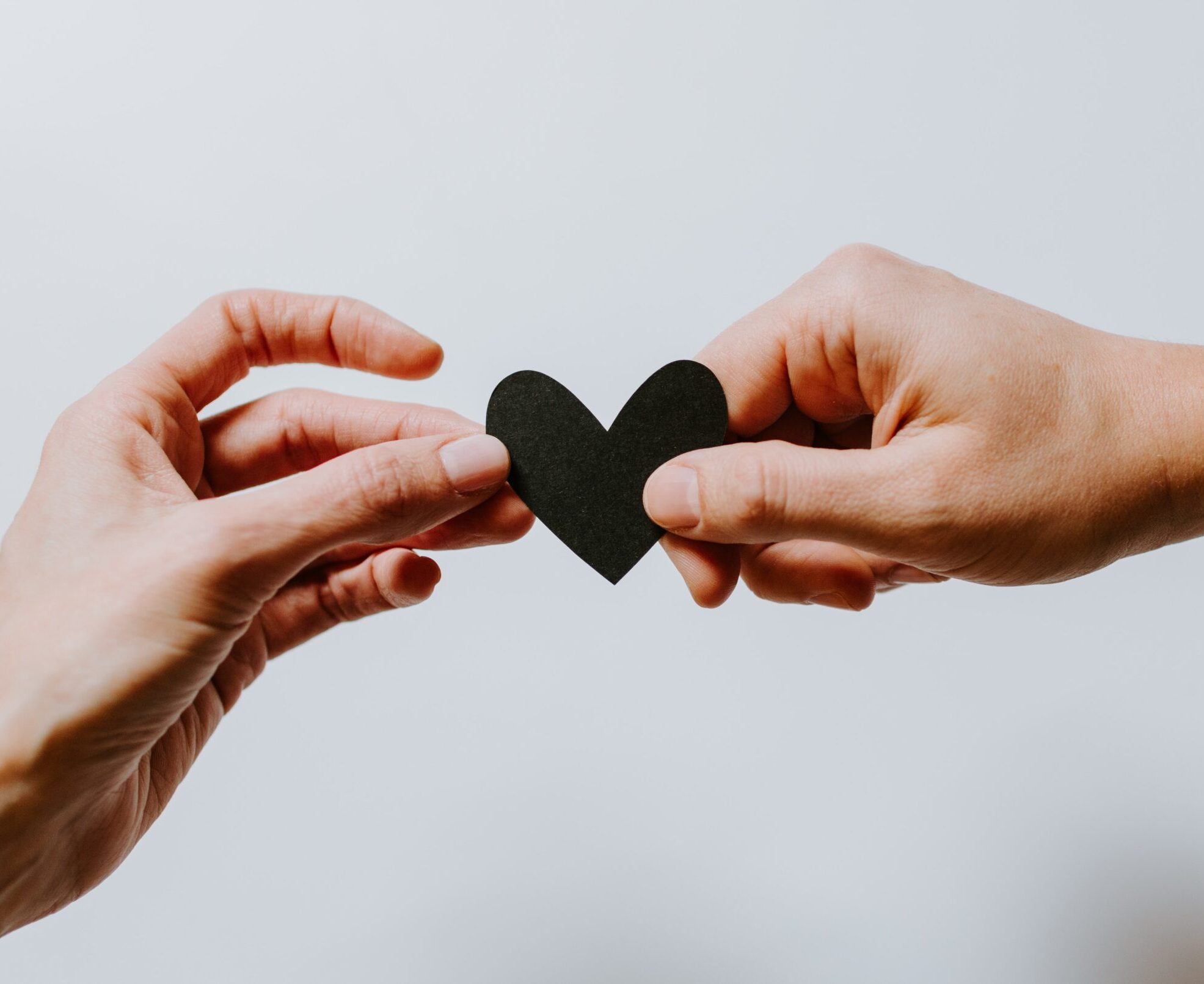 Two people holding paper heart