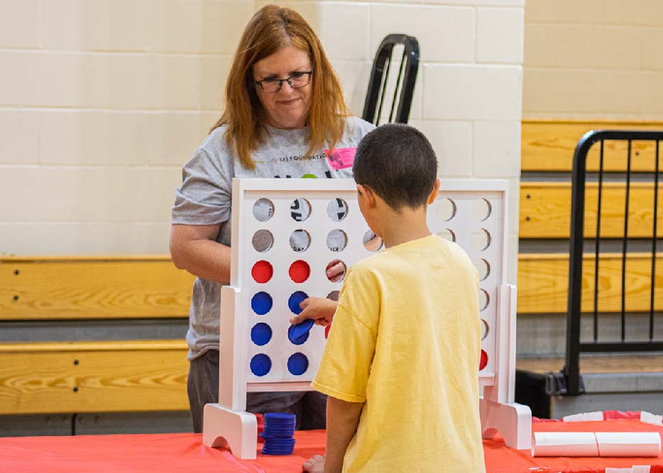 Volunteer with Damar client playing Connect 4